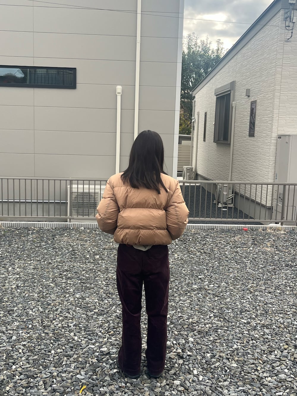 ベージュ系のダウンジャケット/コート、グリーン系のスウェット、レッド系のその他パンツを着用したレディースの冬コーディネートの2枚目の写真