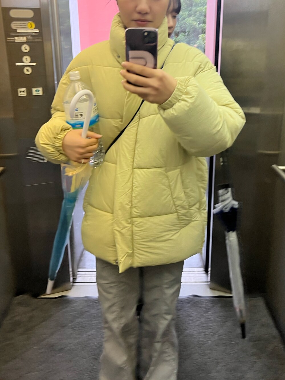 グリーン系のダウンジャケット/コート、グレー系のカーゴパンツ、ホワイト系のスニーカーを着用したレディースの冬コーディネートの2枚目の写真