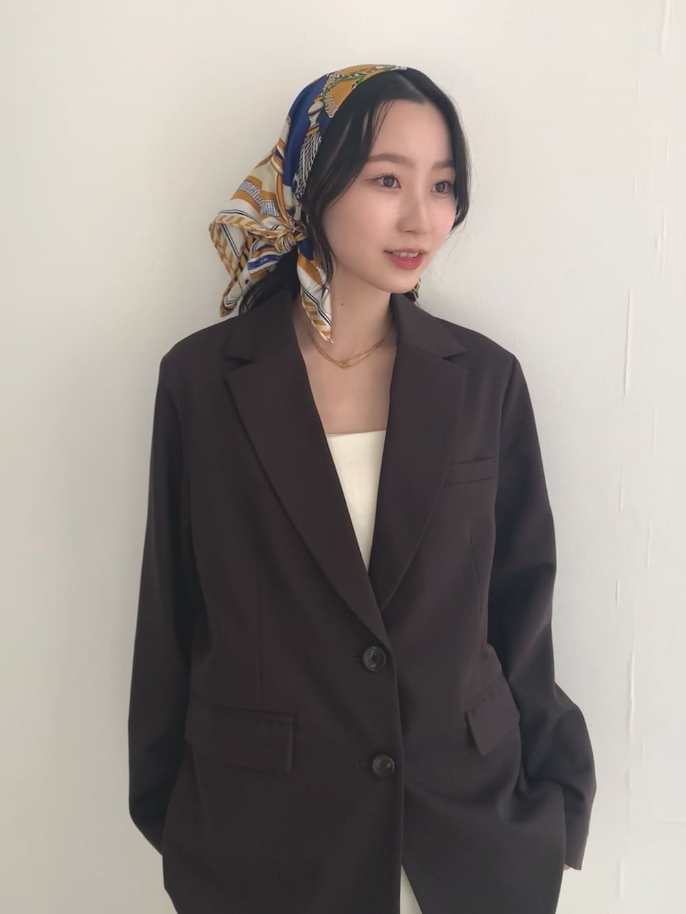 ブラウン系のその他アウター、ホワイト系のその他パンツ、イエロー系のバンダナ/スカーフを着用したレディースの冬コーディネートの2枚目の写真