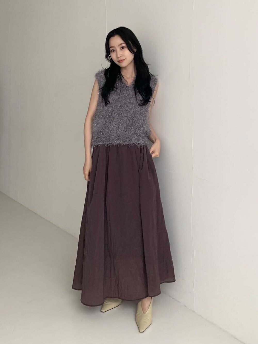 ブラウン系のスカート、グレー系のベストを着用したレディースの夏コーディネートの2枚目の写真