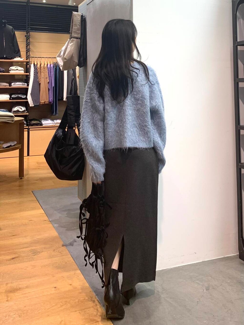 ブラック系のブーツ、グレー系のスカート、ブルー系のカーディガン/ボレロを着用したレディースの冬コーディネートの6枚目の写真
