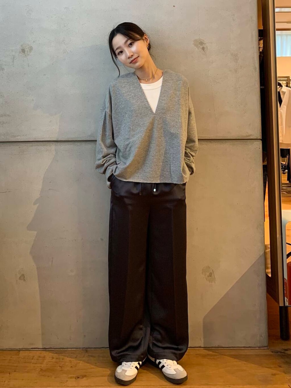 グレー系のその他パンツ、ホワイト系のスニーカー、グレー系のTシャツ/カットソーを着用したレディースの秋コーディネートの2枚目の写真