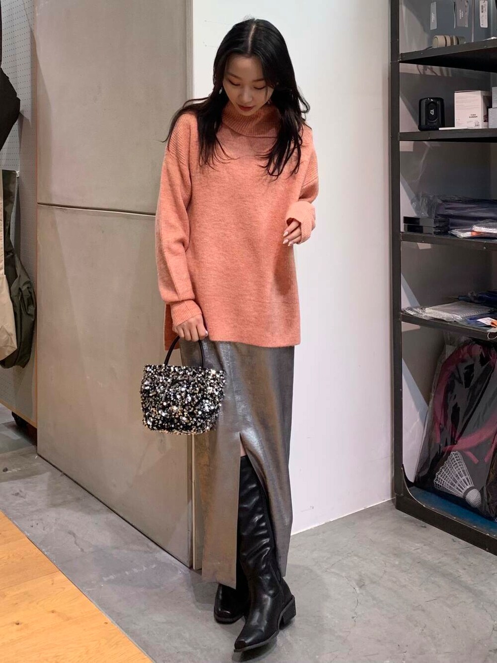 シルバー系のショルダーバッグ、ブラック系のブーツ、シルバー系のスカートを着用したレディースの冬コーディネートの4枚目の写真