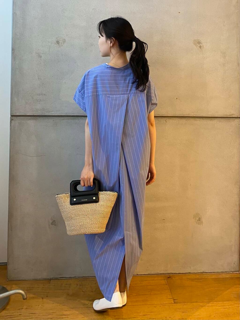 ベージュ系のハンドバッグ、ホワイト系のパンプス、ブルー系のワンピースを着用したレディースの夏コーディネートの6枚目の写真