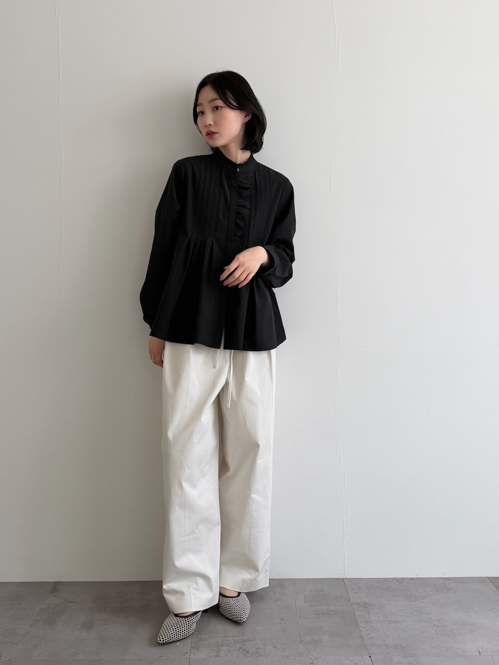 ブラック系のシャツ/ブラウス、ホワイト系のその他パンツ、ブラック系のパンプスを着用したレディースの冬コーディネートの2枚目の写真