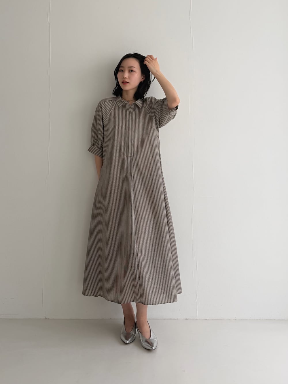 ブラウン系のワンピース、シルバー系のパンプスを着用したレディースの春コーディネートの2枚目の写真