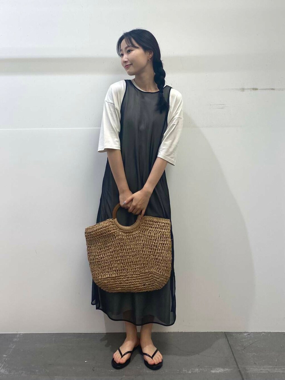 ベージュ系のトートバッグ、ブラック系のサンダル、ブラック系のワンピースを着用したレディースの夏コーディネートの2枚目の写真