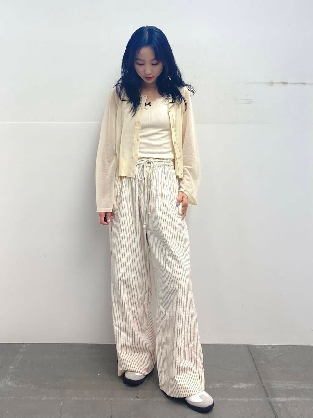 レッド系のその他パンツ、ホワイト系のカーディガン/ボレロ、ホワイト系のスニーカーを着用したレディースの夏コーディネートの2枚目の写真