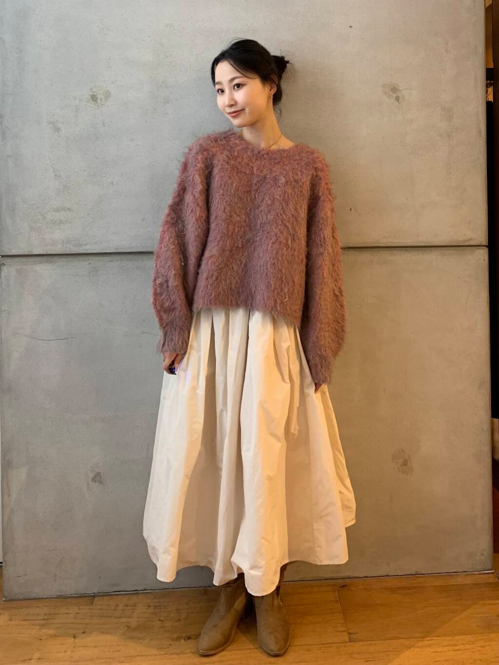 ピンク系のニット/セーター、ホワイト系のスカートを着用したレディースの秋コーディネートの3枚目の写真