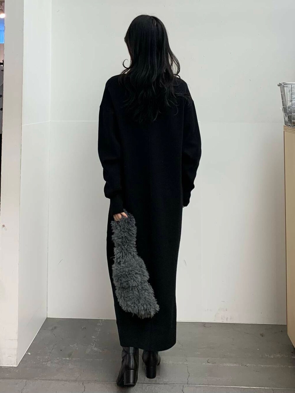 ブラック系のブーツ、グレー系のハンドバッグ、ホワイト系のニット/セーターを着用したレディースの冬コーディネートの6枚目の写真