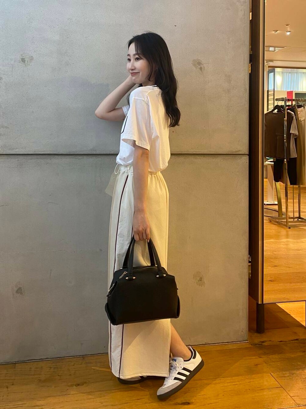 ブラック系のハンドバッグ、ホワイト系のTシャツ/カットソー、ホワイト系のスカートを着用したレディースの夏コーディネートの4枚目の写真