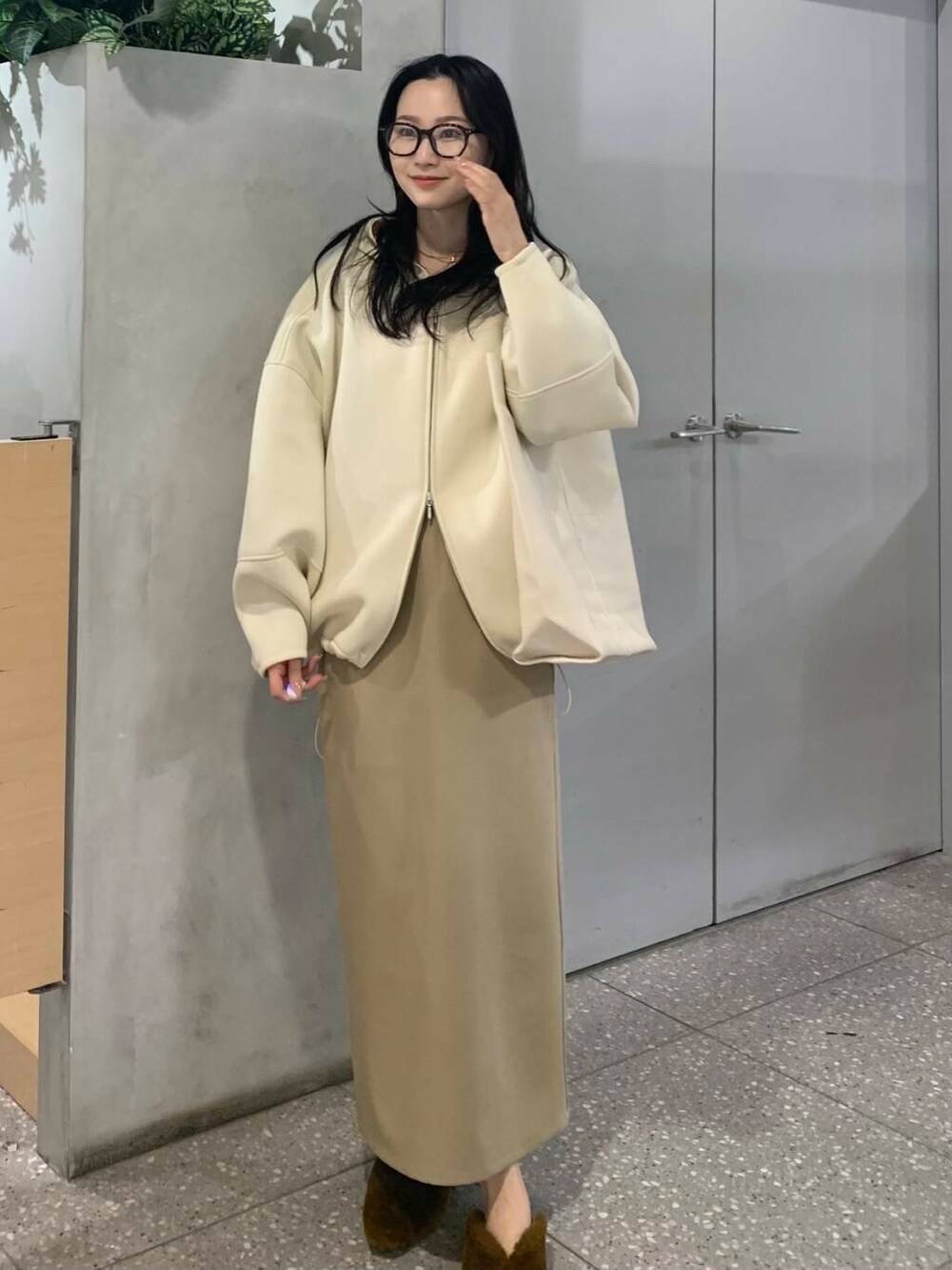 イエロー系のその他シューズ、ベージュ系のスカート、ホワイト系のパーカーを着用したレディースの冬コーディネートの3枚目の写真