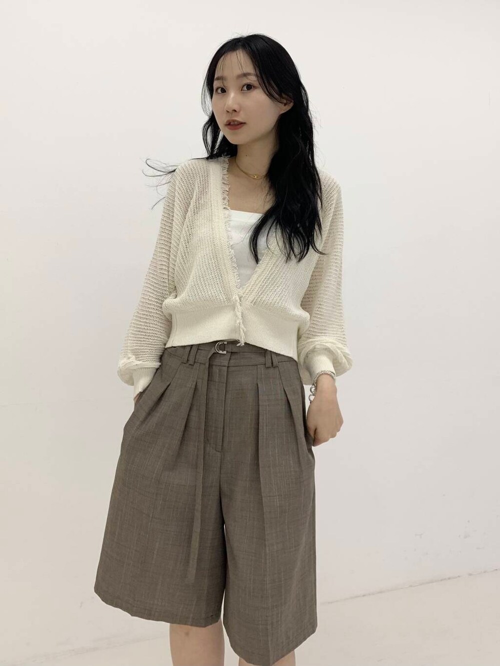 ブラウン系のその他パンツ、ホワイト系のカーディガン/ボレロを着用したレディースの春コーディネートの3枚目の写真