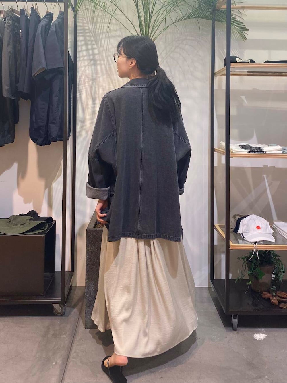 グリーン系のワンピース、ブラック系のサンダル、ブルー系のタンクトップを着用したレディースの夏コーディネートの6枚目の写真