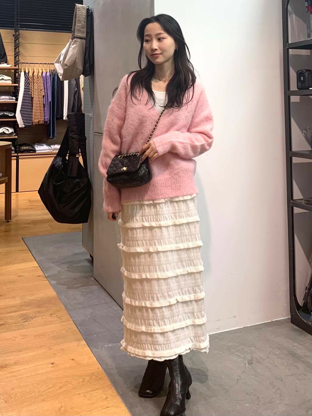 ブラック系のショルダーバッグ、ブラック系のブーツ、ピンク系のニット/セーターを着用したレディースの冬コーディネートの3枚目の写真