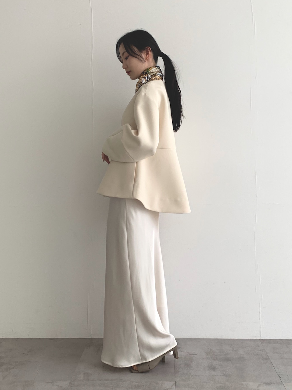 ホワイト系のノーカラージャケット、ホワイト系のスカート、イエロー系のバンダナ/スカーフを着用したレディースの春コーディネートの2枚目の写真