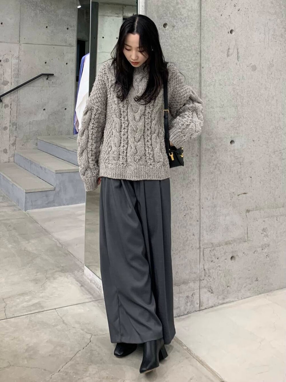 グレー系のニット/セーター、ブラック系のブーツ、グレー系のその他パンツを着用したレディースの冬コーディネートの3枚目の写真