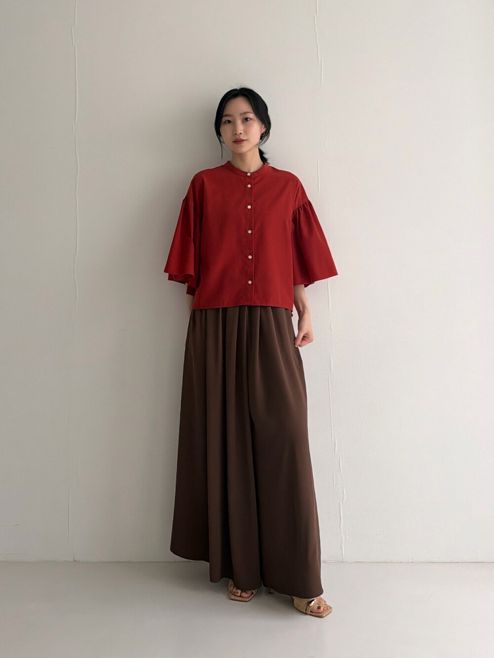 レッド系のシャツ/ブラウス、ブラウン系のその他パンツ、ブラウン系のパンプスを着用したレディースの春コーディネートの2枚目の写真