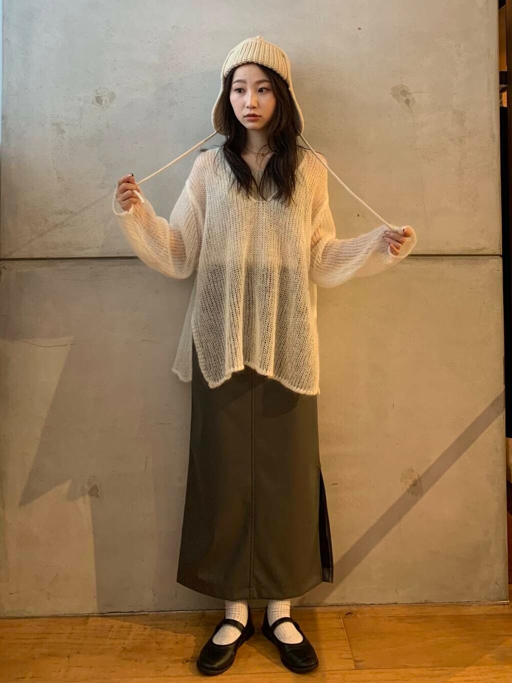 ベージュ系のタンクトップ、グレー系のスカート、ホワイト系のニット/セーターを着用したレディースの秋コーディネートの4枚目の写真