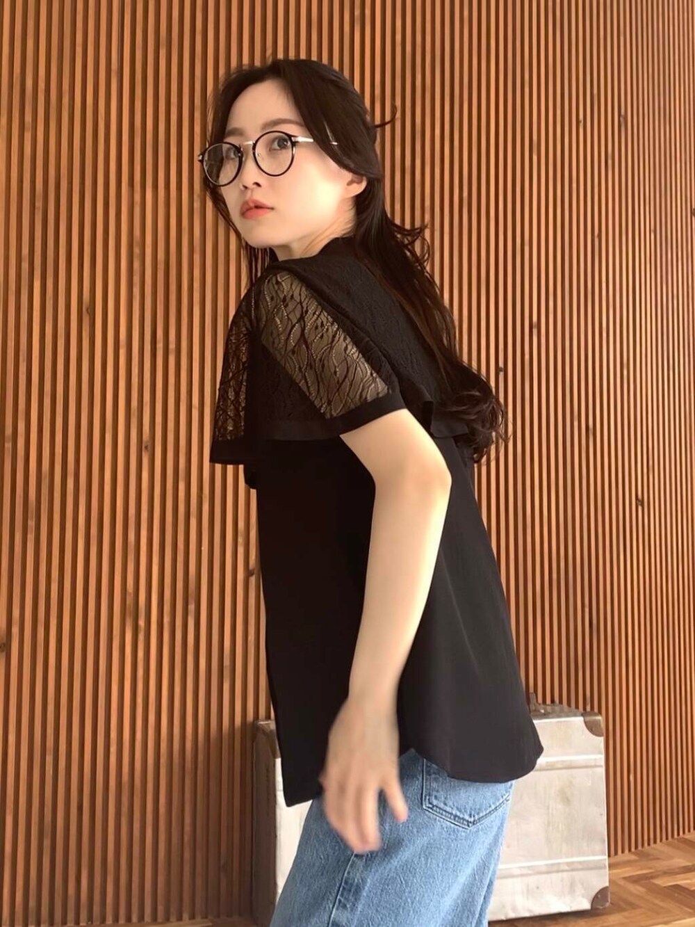 ベージュ系のショルダーバッグ、ブルー系のデニムパンツ、ブラック系のシャツ/ブラウスを着用したレディースの夏コーディネートの4枚目の写真