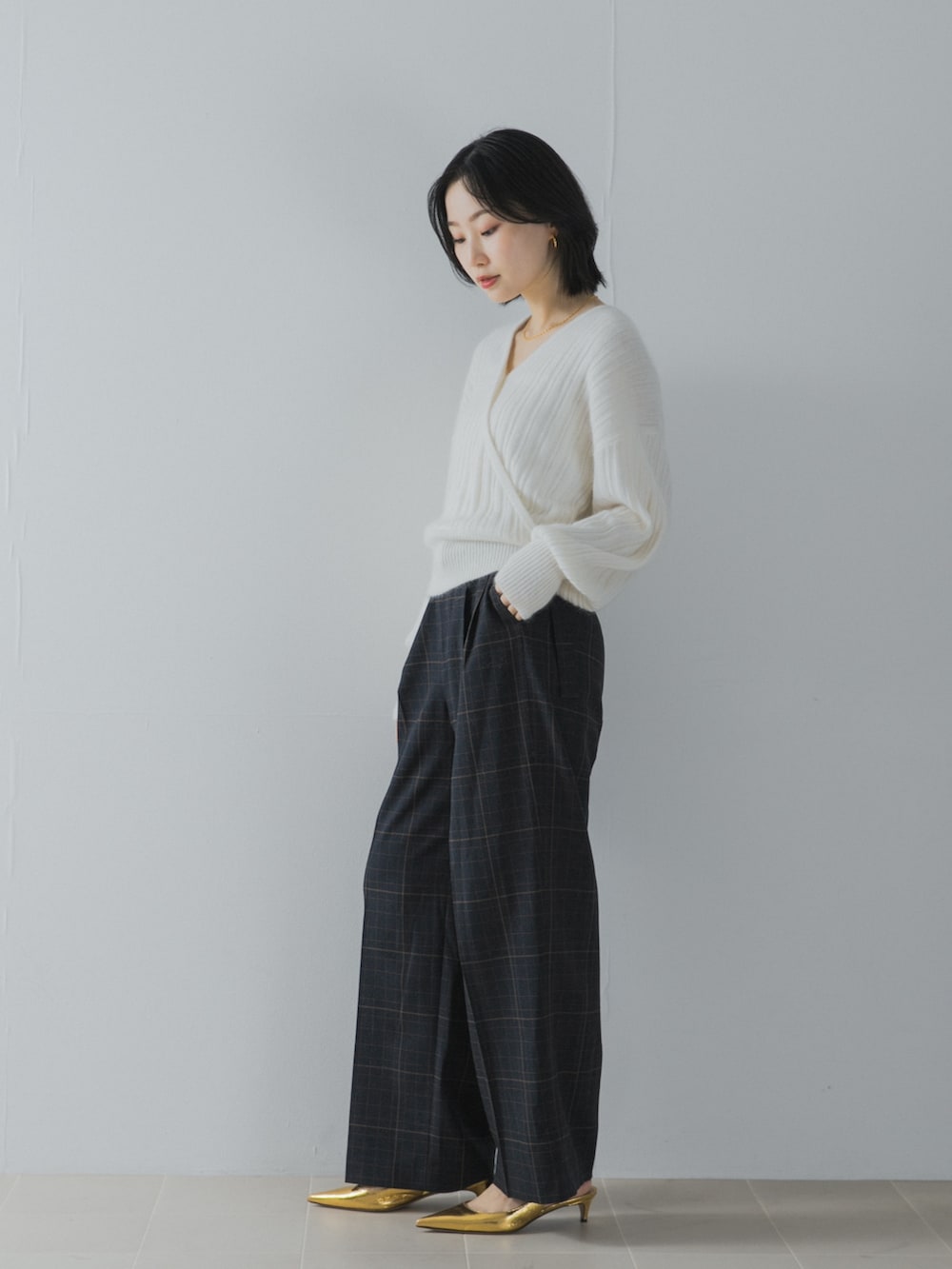 ホワイト系のニット/セーター、ブルー系のその他パンツ、ゴールド系のパンプスを着用したレディースの夏コーディネートの4枚目の写真