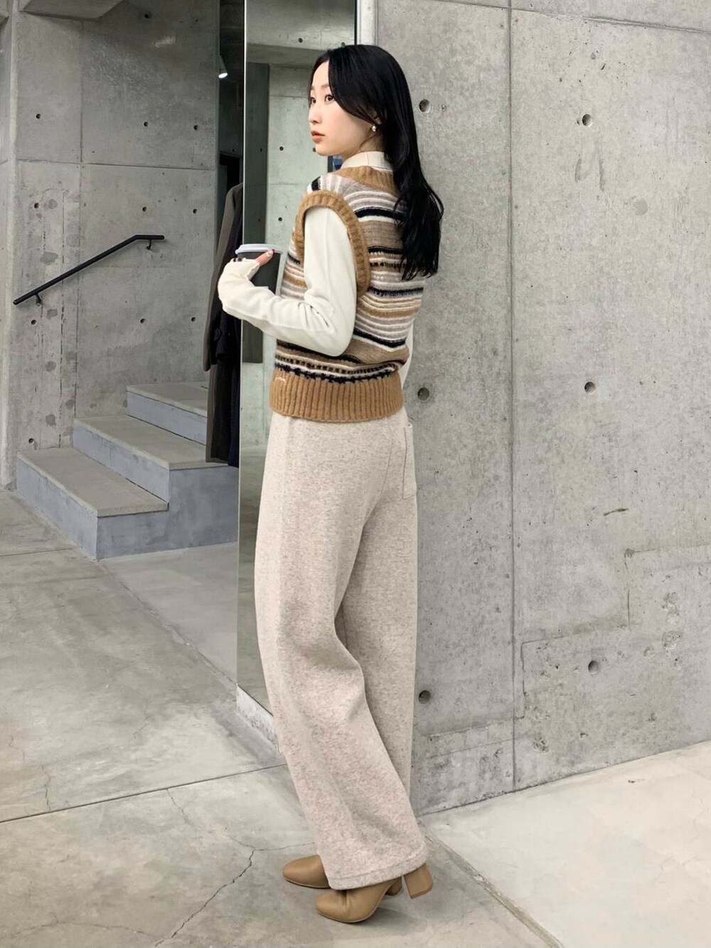 ベージュ系のブーツ、ブラウン系のベスト、ベージュ系のその他パンツを着用したレディースの冬コーディネートの5枚目の写真