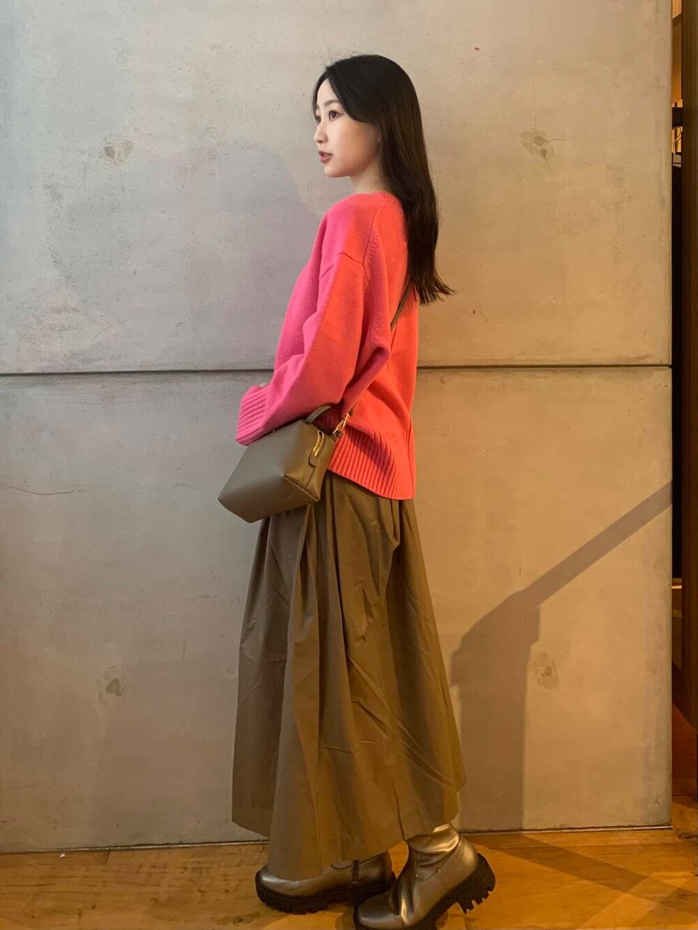 シルバー系のブーツ、ブラウン系のスカート、ピンク系のニット/セーターを着用したレディースの秋コーディネートの4枚目の写真