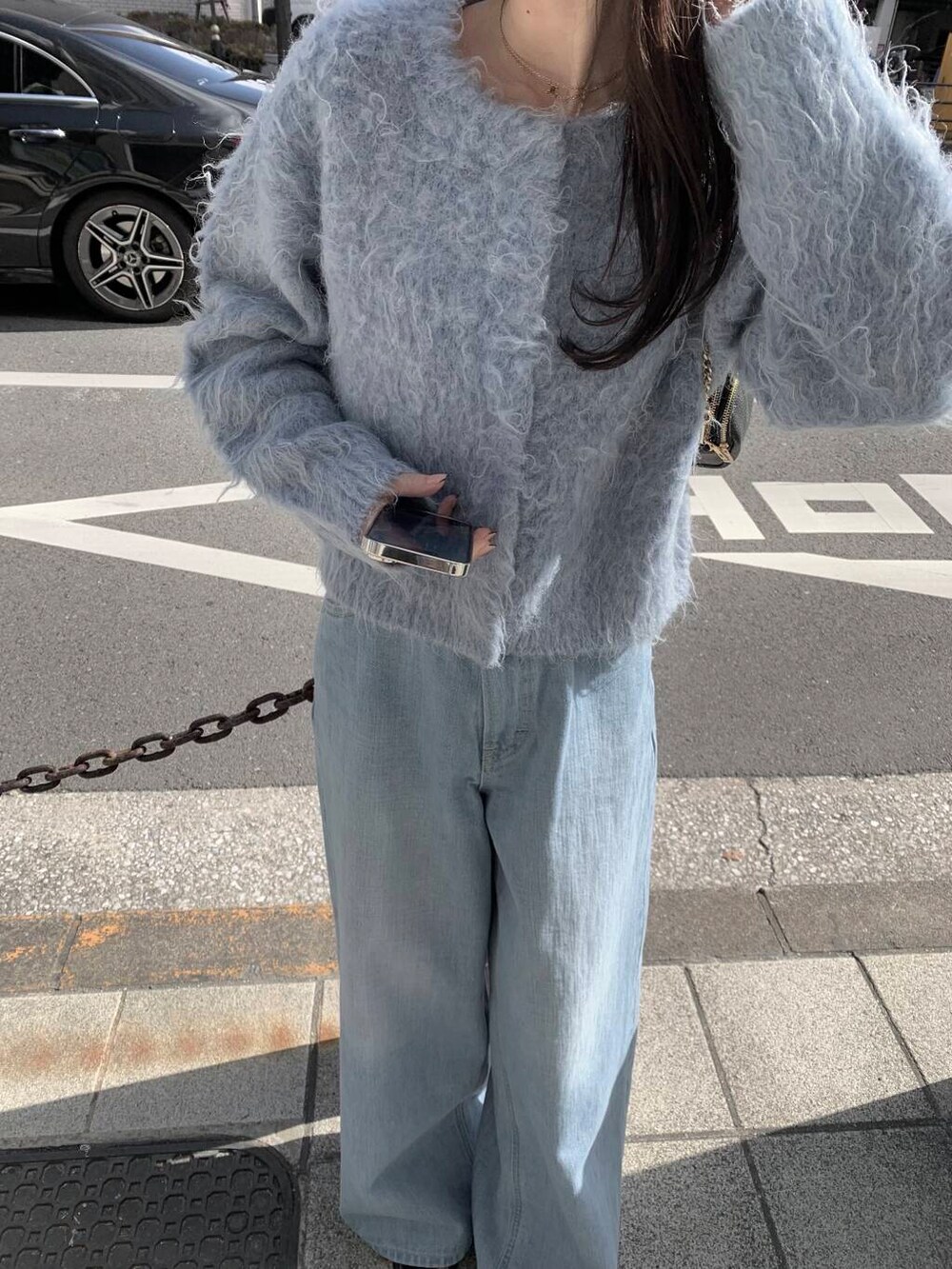 ブルー系のカーディガン/ボレロ、ブルー系のデニムパンツを着用したレディースの冬コーディネートの3枚目の写真