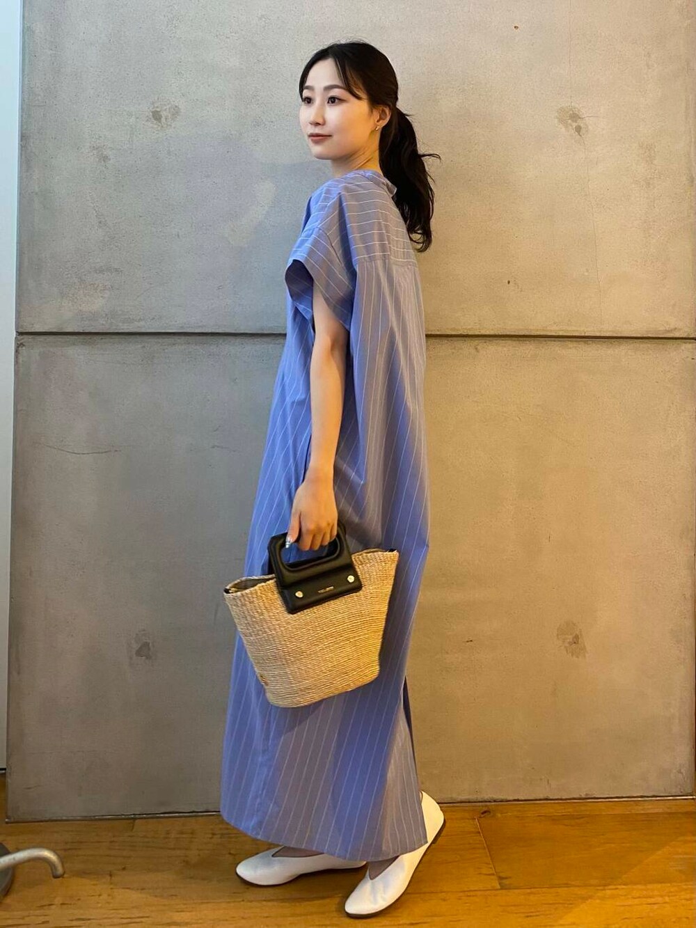 ベージュ系のハンドバッグ、ホワイト系のパンプス、ブルー系のワンピースを着用したレディースの夏コーディネートの5枚目の写真