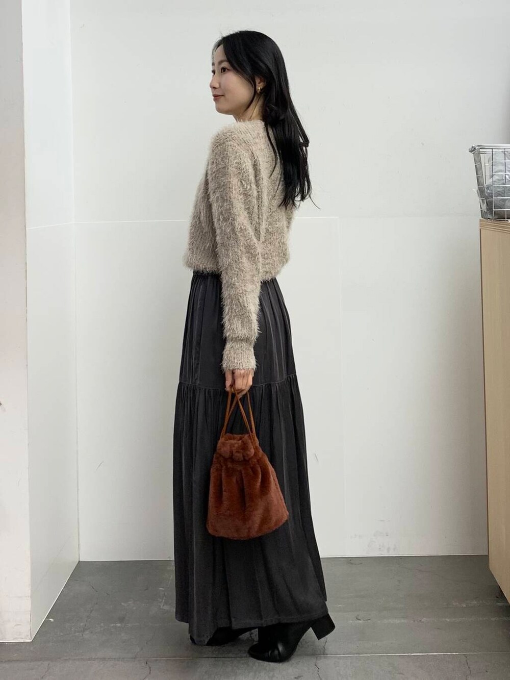 ブラック系のブーツ、ブラウン系のショルダーバッグ、グレー系のスカートを着用したレディースの冬コーディネートの5枚目の写真