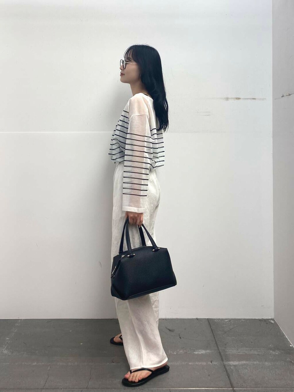 ブラック系のサンダル、ブラック系のハンドバッグ、ホワイト系のその他パンツを着用したレディースの夏コーディネートの5枚目の写真