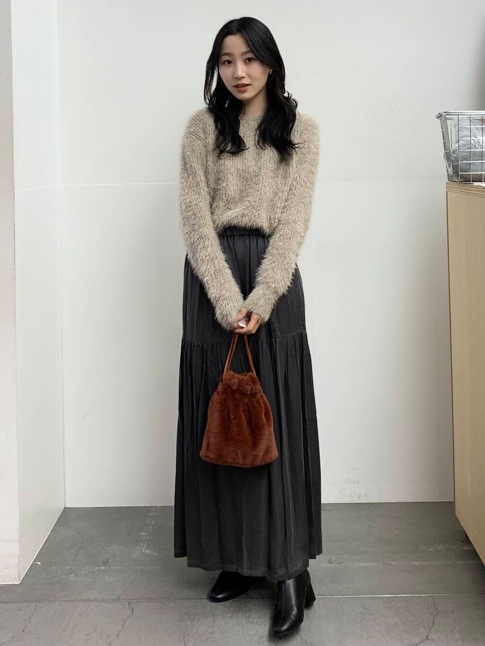 ブラック系のブーツ、ブラウン系のショルダーバッグ、グレー系のスカートを着用したレディースの冬コーディネートの4枚目の写真