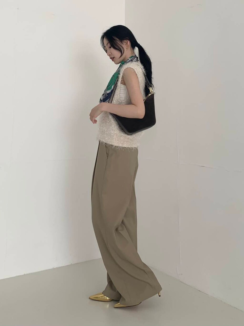 ベージュ系のその他パンツ、ホワイト系のベスト、ブラウン系のショルダーバッグを着用したレディースの夏コーディネートの3枚目の写真