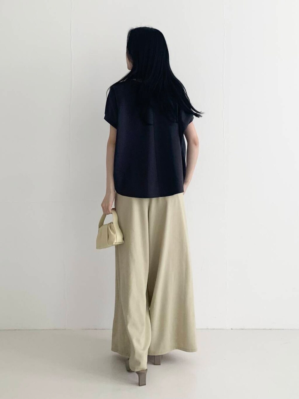 ベージュ系のその他パンツ、イエロー系のハンドバッグ、ブラウン系のTシャツ/カットソーを着用したレディースの春コーディネートの6枚目の写真