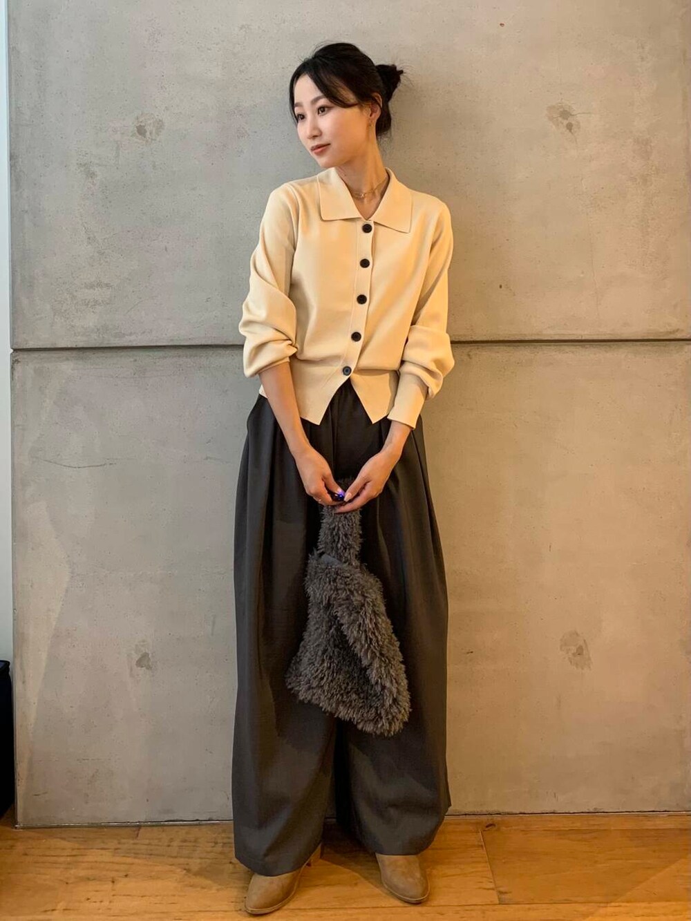 ホワイト系のカーディガン/ボレロ、グレー系のその他パンツ、グレー系のハンドバッグを着用したレディースの秋コーディネートの2枚目の写真