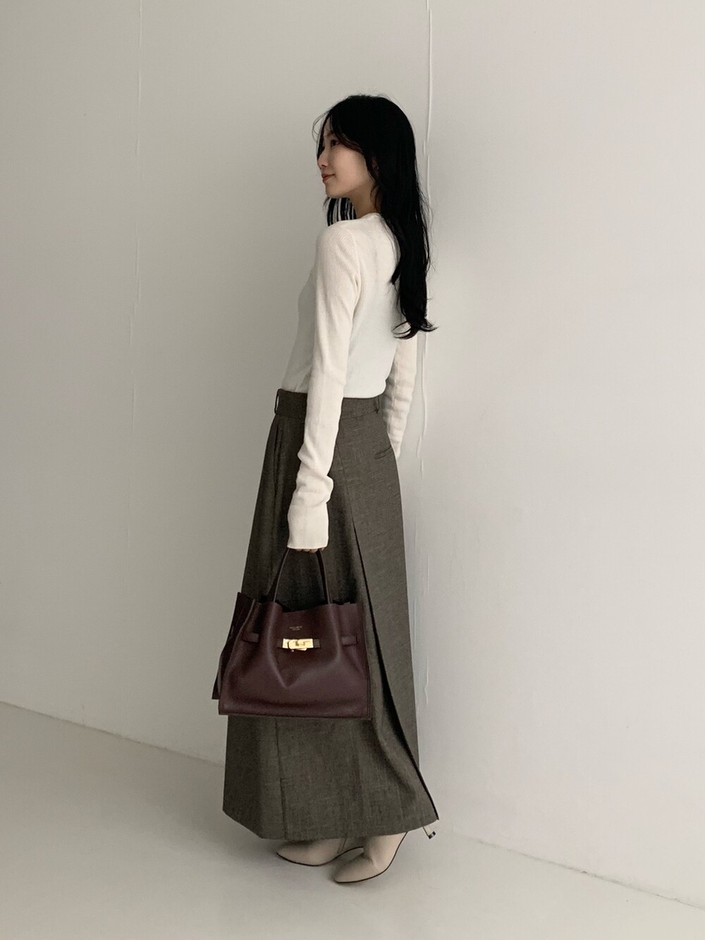 ホワイト系のニット/セーター、ブラウン系のスカートを着用したレディースの秋コーディネートの4枚目の写真
