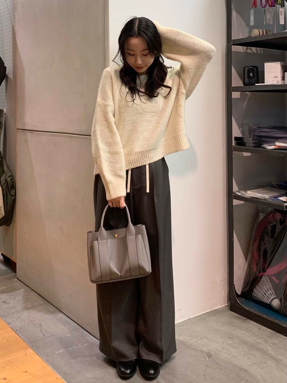 ブラック系のブーツ、グレー系のトートバッグ、ホワイト系のニット/セーターを着用したレディースの冬コーディネートの5枚目の写真