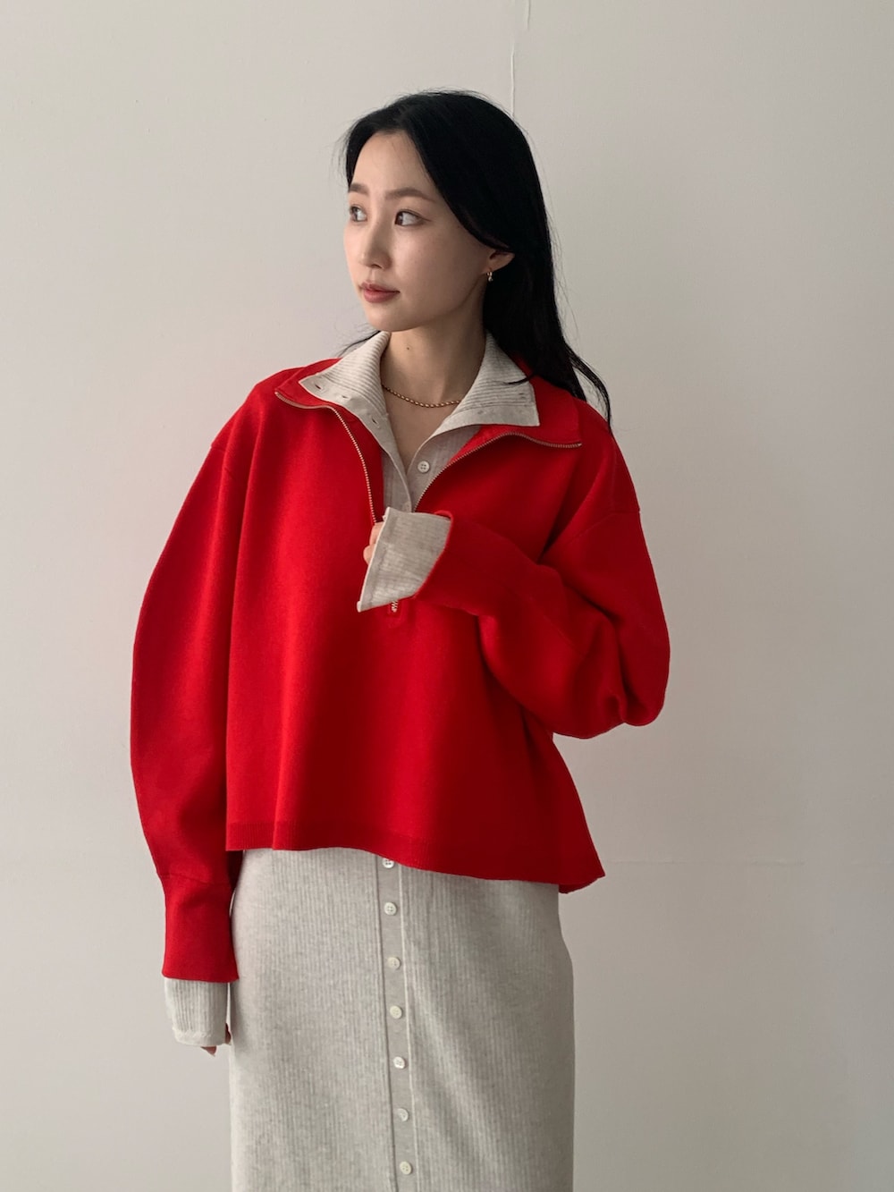 レッド系のニット/セーター、ベージュ系のワンピース、ブラック系のその他シューズを着用したレディースの秋コーディネートの3枚目の写真