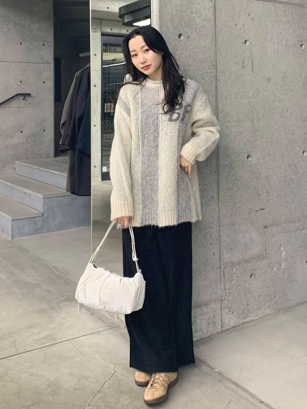ブラック系のその他パンツ、グリーン系のニット/セーター、ホワイト系のショルダーバッグを着用したレディースの冬コーディネートの5枚目の写真