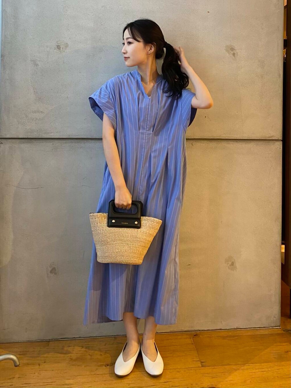 ベージュ系のハンドバッグ、ホワイト系のパンプス、ブルー系のワンピースを着用したレディースの夏コーディネートの2枚目の写真