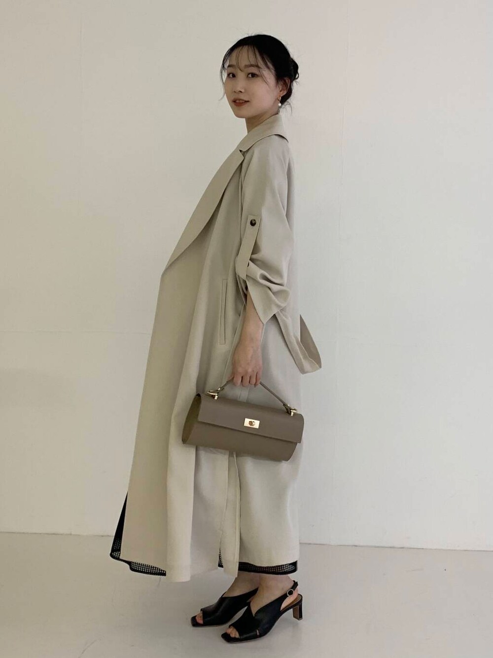 グレー系のシャツ/ブラウス、ホワイト系のトレンチコート、ブラック系のスカートを着用したレディースの春コーディネートの3枚目の写真