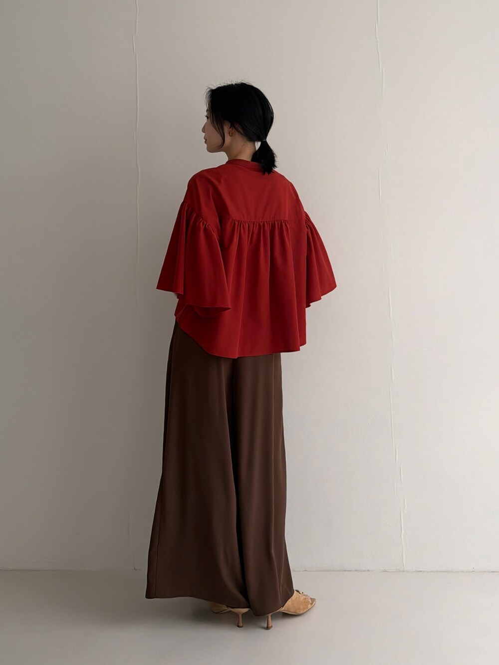 レッド系のシャツ/ブラウス、ブラウン系のその他パンツ、ブラウン系のパンプスを着用したレディースの春コーディネートの4枚目の写真