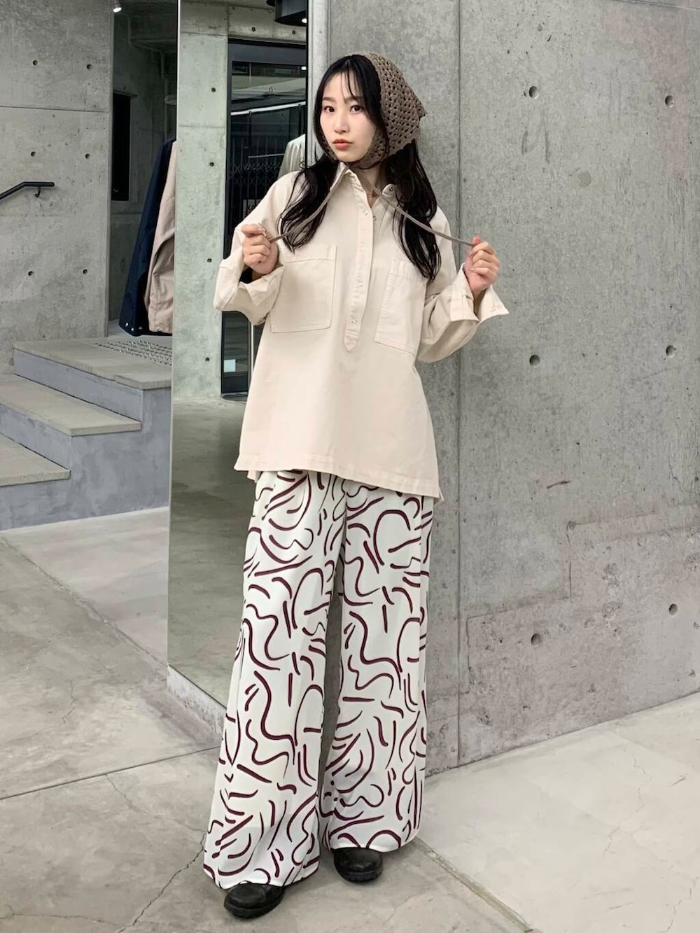 レッド系のその他パンツ、ホワイト系のシャツ/ブラウス、ベージュ系のバンダナ/スカーフを着用したレディースの冬コーディネートの2枚目の写真