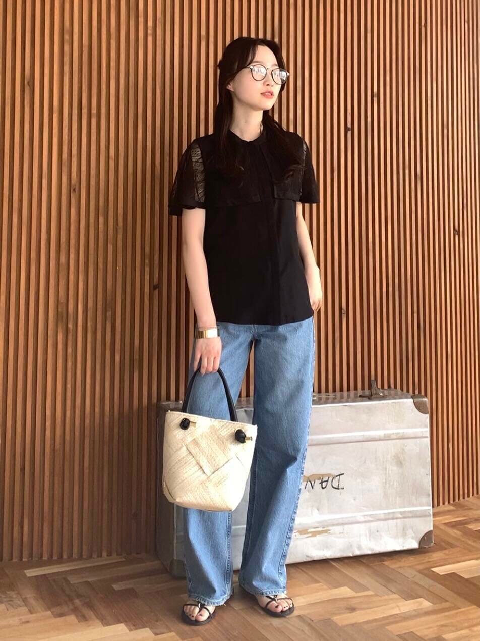 ベージュ系のショルダーバッグ、ブルー系のデニムパンツ、ブラック系のシャツ/ブラウスを着用したレディースの夏コーディネートの2枚目の写真