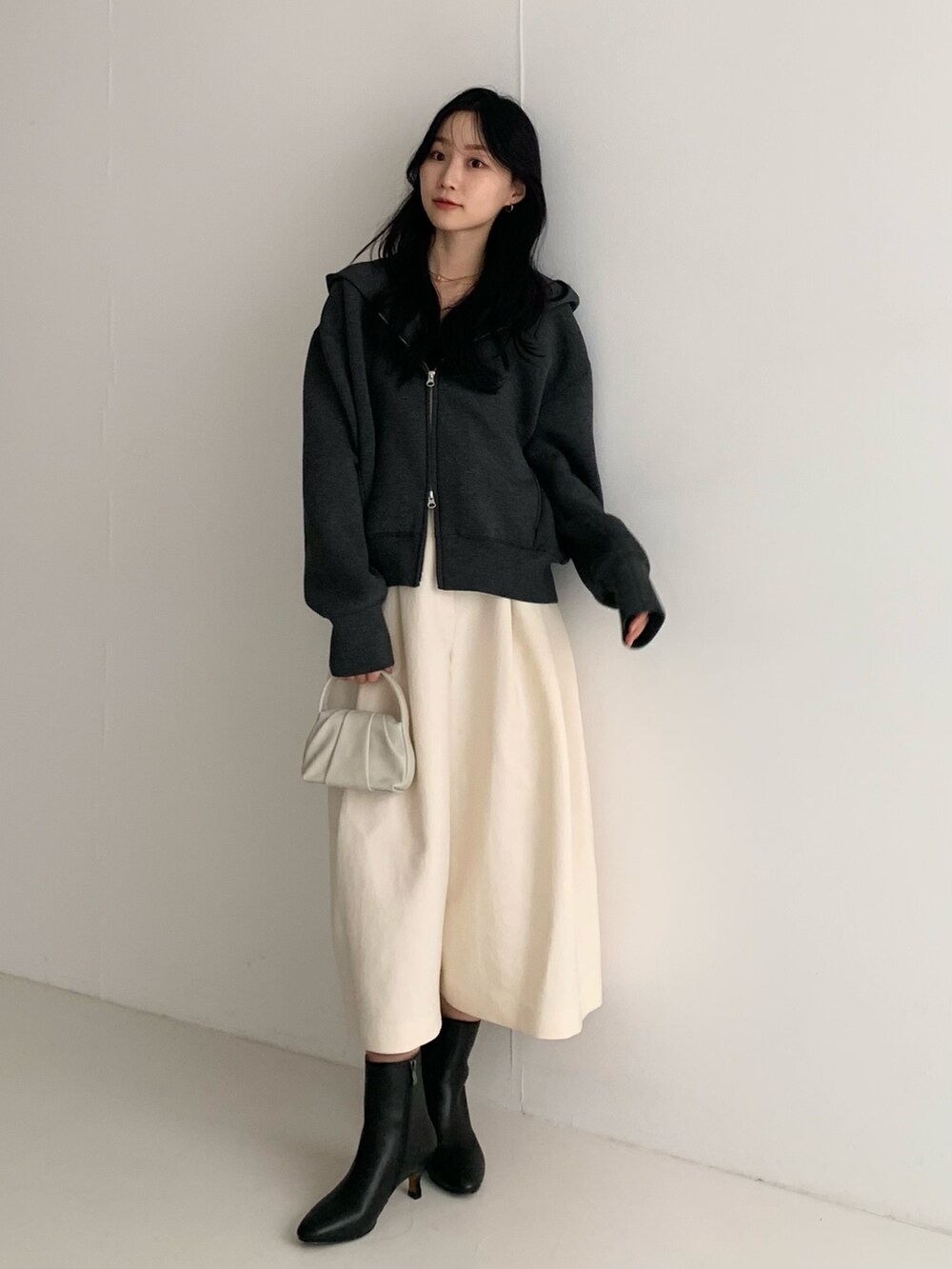 グレー系のパーカー、ホワイト系のその他パンツ、ホワイト系のハンドバッグを着用したレディースの秋コーディネートの2枚目の写真