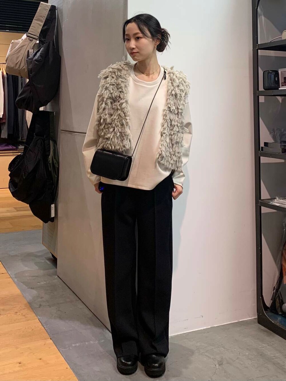 ブラック系のブーツ、グレー系のスウェット、グレー系のベストを着用したレディースの冬コーディネートの3枚目の写真