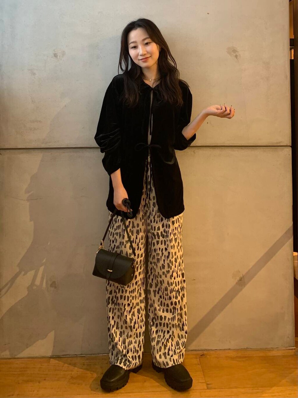 ブラック系のショルダーバッグ、ホワイト系のその他パンツ、ブラック系のブーツを着用したレディースの秋コーディネートの3枚目の写真