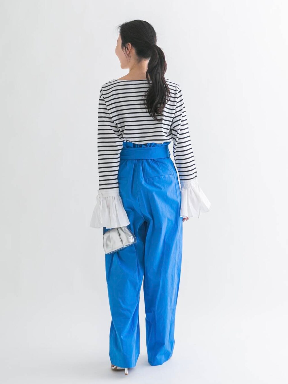 シルバー系のハンドバッグ、ブルー系のその他パンツを着用したレディースの春コーディネートの3枚目の写真