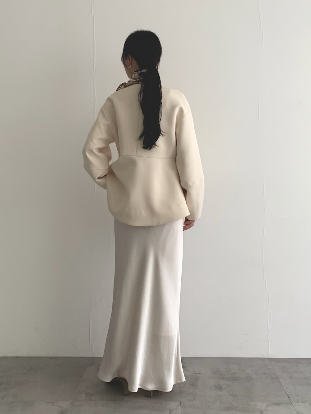 ホワイト系のノーカラージャケット、ホワイト系のスカート、イエロー系のバンダナ/スカーフを着用したレディースの春コーディネートの3枚目の写真