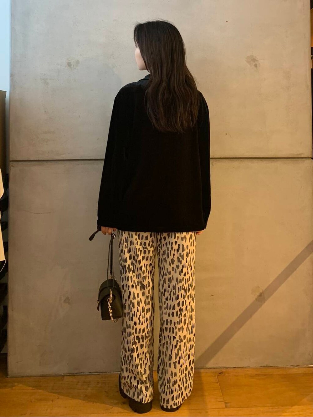 ブラック系のショルダーバッグ、ホワイト系のその他パンツ、ブラック系のブーツを着用したレディースの秋コーディネートの7枚目の写真